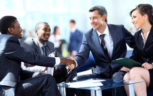 man and woman shaking hands at the conclusion of a meeting, dressed in business atire